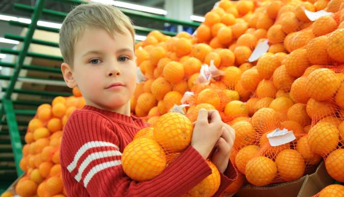 otrok s pomarančami