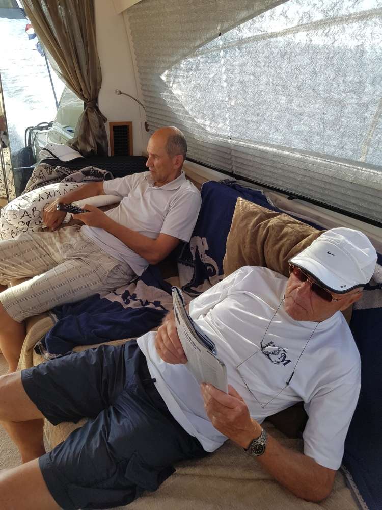 Božo Dimnik med popoldanskim branjem Demokracije, strankarskega tednika SDS, na jahti Andreja Marčiča. Ob njem sedi Janez Janša.