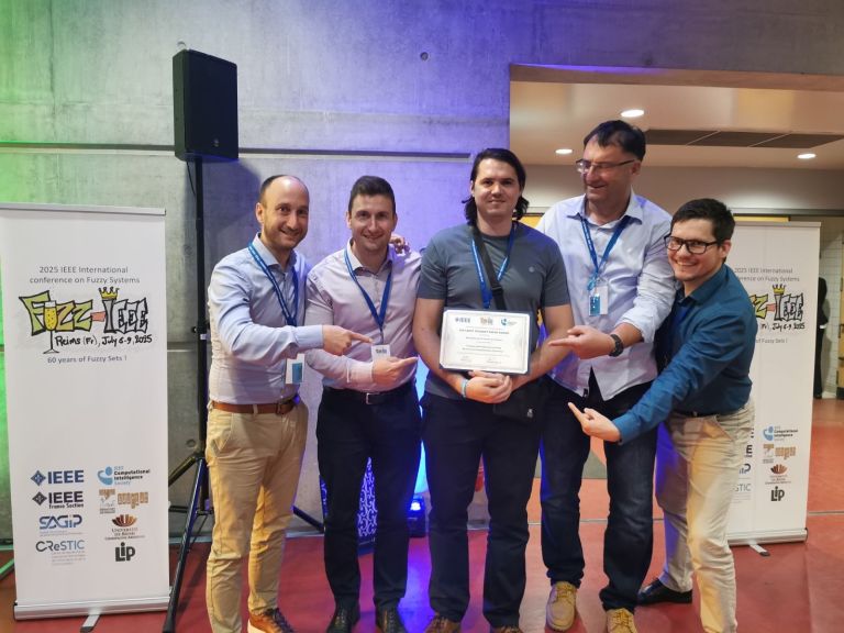 Miha Ožbot, mag. inž. el. z ekipo ob prejemu nagrade za najboljši študentski članek na FUZZ-IEEE 2025 (foto_Igor Škrjanc).jpg