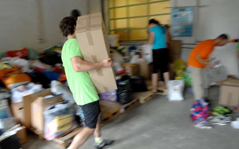 Prostovoljci pri sortiranju humanitarne pomoči
