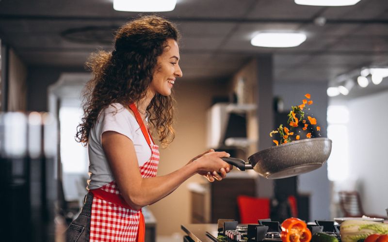 woman-chef-cooking-vegetables-pan.jpg