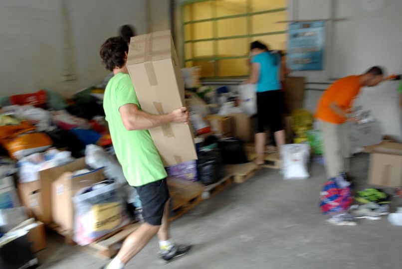 Prostovoljci pri sortiranju humanitarne pomoči