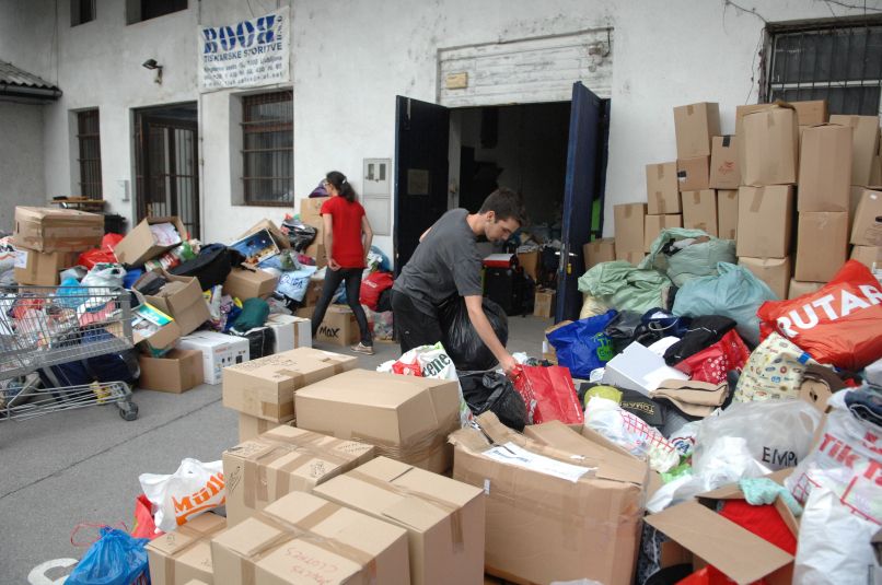Prostovoljci pri sortiranju humanitarne pomoči