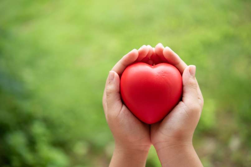 child-holding-red-rubber-heart