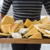 mid-section-woman-holding-cheese-slices-wooden-tray.jpg