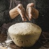 front-view-female-chef-dusting-her-hands-with-flour-before-handling-pizza-dough.jpg