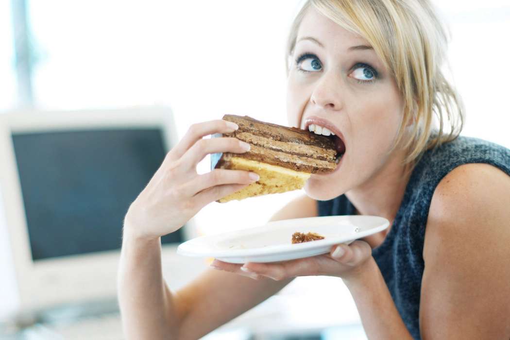 Close-up-of-a-woman-eating-a-large-piece-of-cake