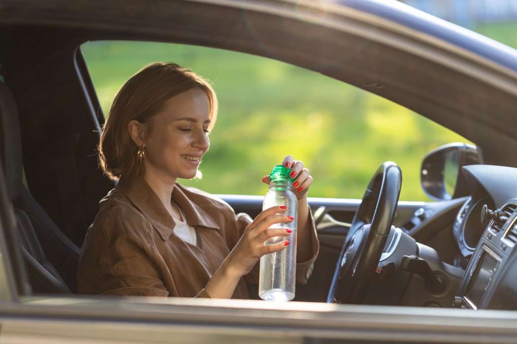 steklenica vode, avto, poletje, pitje med vožnjo, vročina 