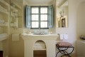 Svetla in enostavna kopalnica, ki dobro izkorišča stare zidane elemente.