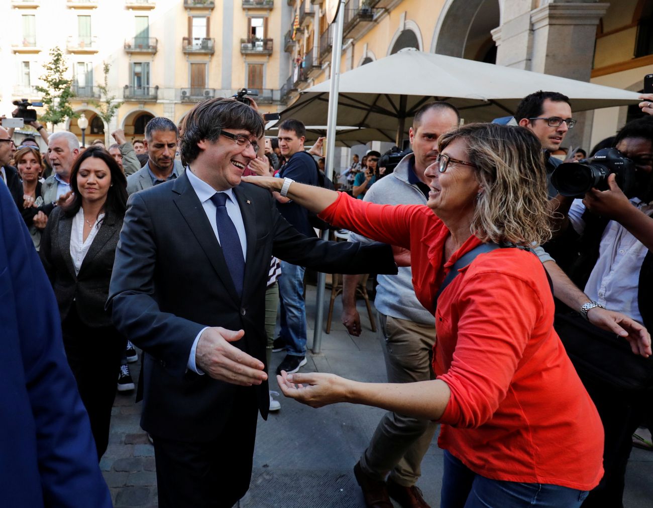 Sacked Catalan President Carles Puigdemont greets a supporter after leaving a restaurant the day