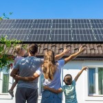 srečna družina pred energetsko varčno hišo