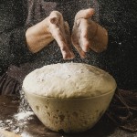 front-view-female-chef-dusting-her-hands-with-flour-before-handling-pizza-dough