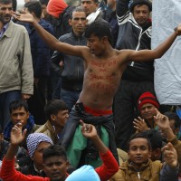 Migrants react, as they wait to cross the border from Greece to Gevgelija