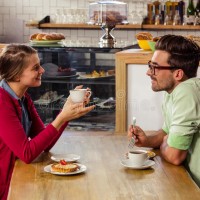 couple-sitting-table-talking-cafeteria-77688768