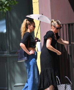 Jennifer Lawrence se pred soncem ščiti kar z dežnikom