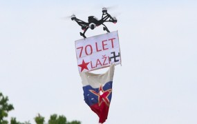 Z dronom s preluknjano 'jugo' zastavo in napisom "70 let laži" nad Kučanov govor
