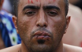 Na meji ujeti migranti so si protestno zašili usta