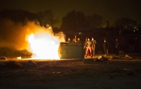 Divjanje migrantov: zažigajo gume, obmetavajo policiste