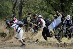 Več sto migrantov čez ograjo in mimo policije vdrlo v Makedonijo
