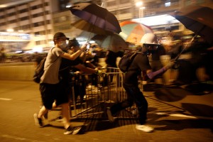 Skupine s palicami oboroženih moških so v Hongkongu pretepale protestnike in novinarje