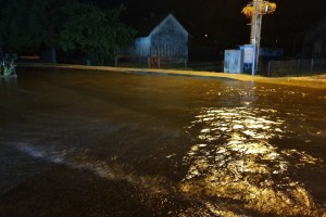 V Prekmurju in Kočevju narasle vode zalile hiše, na Vrhniki je veter prevračal šotore