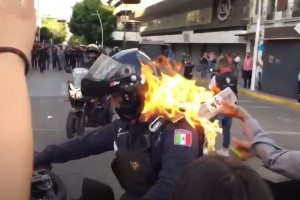 Grozljivo: psihopatski protestnik je policista kar zažgal (VIDEO)