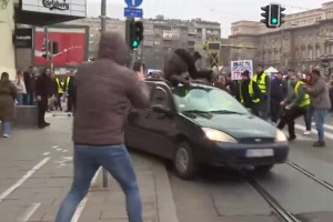 Nori voznik z avtom med protestnike: dekle je pristalo na strehi vozila (VIDEO)