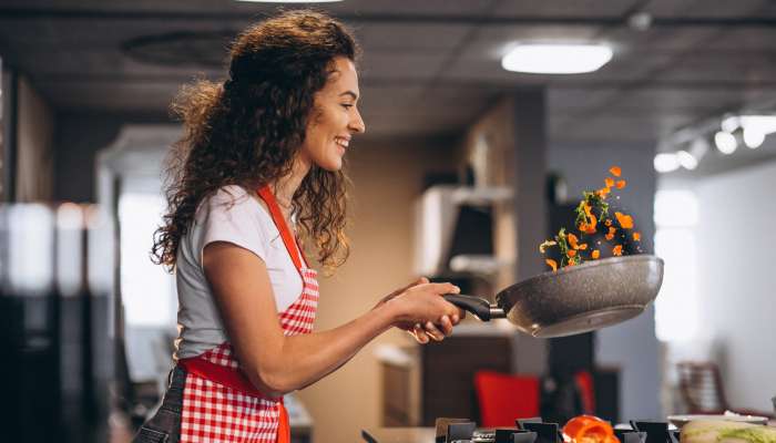 woman-chef-cooking-vegetables-pan