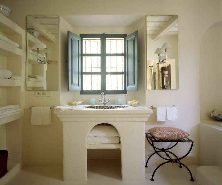 Svetla in enostavna kopalnica, ki dobro izkorišča stare zidane elemente.