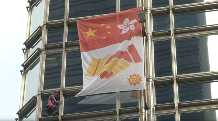 "Francoski spiderman" je sredi protestov splezal na stolpnico v Hongkongu in izobesil zastavo miru