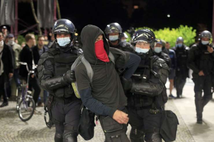 Incident na protestih: policija nad protestnike, ki so s kredo pisali po tleh pred sedežem SMC