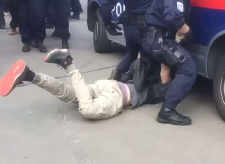 Šokantno: malo je manjkalo, pa bi policijski kombi pridržanemu moškemu zapeljal čez glavo (VIDEO)