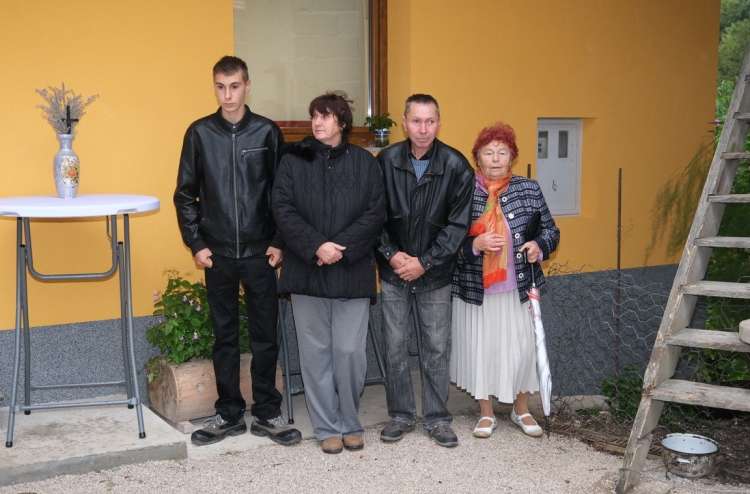 Družina Dolar pred vhodom v prenovljeno hišo