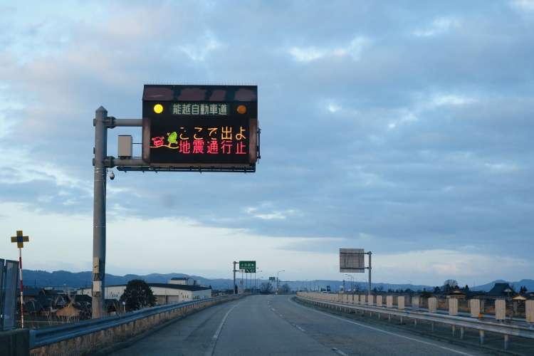 Napis na avtocesti, ki nagovarja voznike, naj takoj zapustijo avtocesto zaradi prihajajočega cunamija.