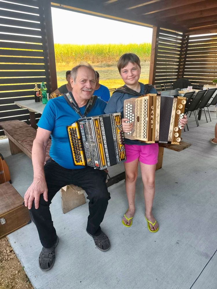 Vlado Matkovič (Fantje z vseh vetrov) in mlada harmonikarka Živa.
