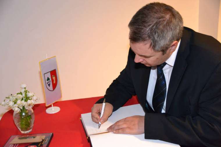 minister Dejan Zidan med podpisom v spominsko knjigo obcine