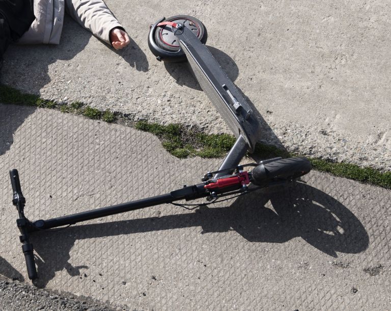 full-shot-man-electric-scooter-laying-ground.jpg