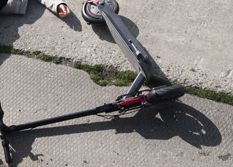 full-shot-man-electric-scooter-laying-ground.jpg