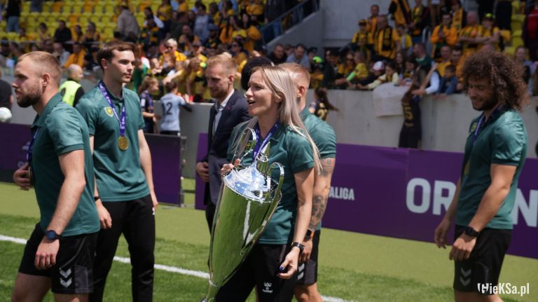 with the trophy Karolina Koch (team coach).png
