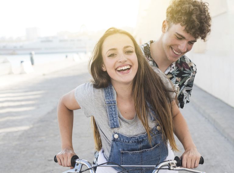 smiling-young-couple-riding-bicycle.jpg