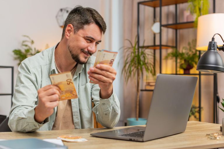 vesel moški prešteva denar