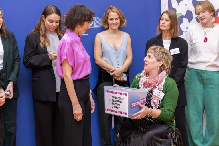 Hadja Lahbib, 3rd from the left, receiving a present from a member of 'My Voice, My Choice'..jpg