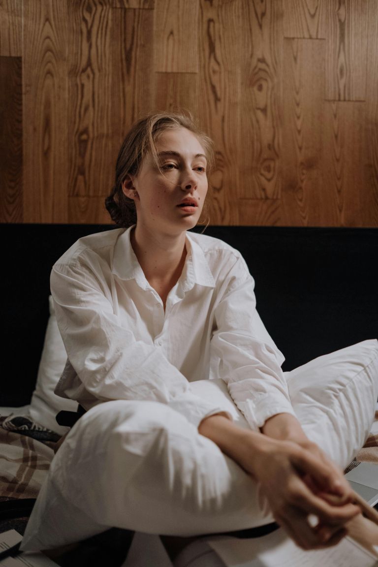 utrujena ženska na postelji