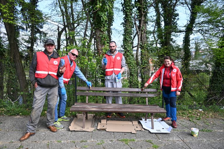 Prostovoljci Rdečega križa pri barvanju klopc pred DSO-jem.JPG