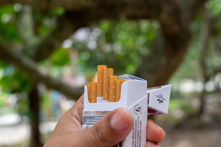 škatlica cigaret v roki