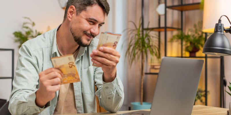 vesel moški prešteva denar