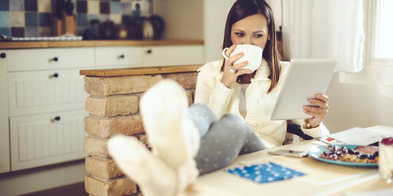 ženska s tablico in kavo