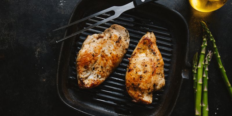 fried-appetizing-tasty-chicken-breast-served-skillet-with-asparagus-dark-background.jpg