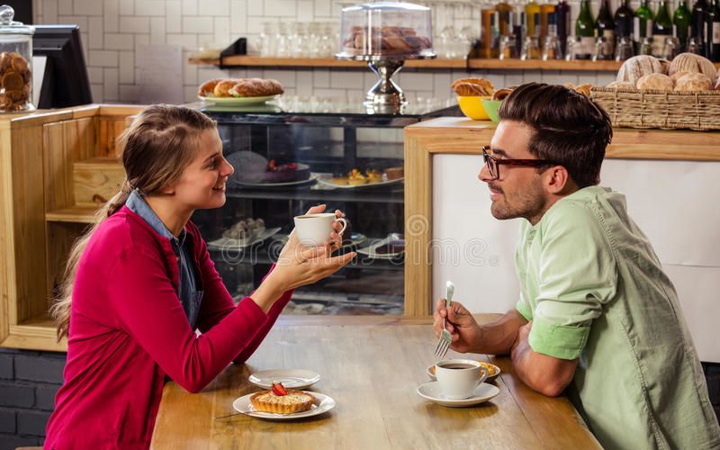 couple-sitting-table-talking-cafeteria-77688768.jpg