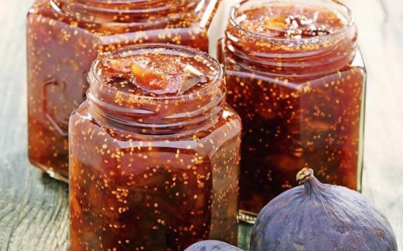 Figs and homemade jam in glass jars.